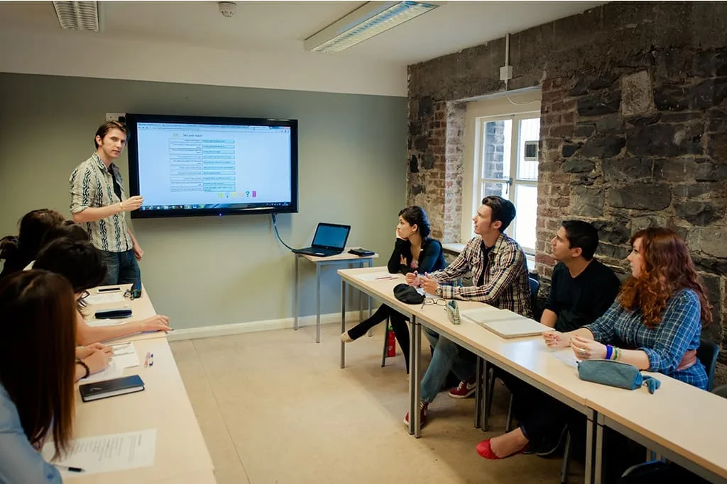 English teacher leading a lesson with international students in an ISI Dublin classroom.
