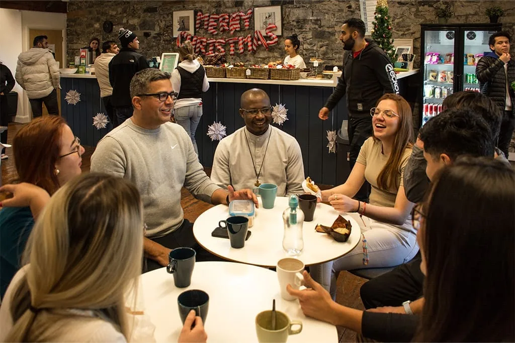 International students socialising in the ISI Dublin common area during a festive Christmas gathering.