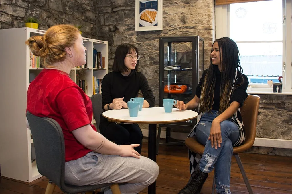 Students chatting over coffee in a relaxed common area at ISI Dublin.