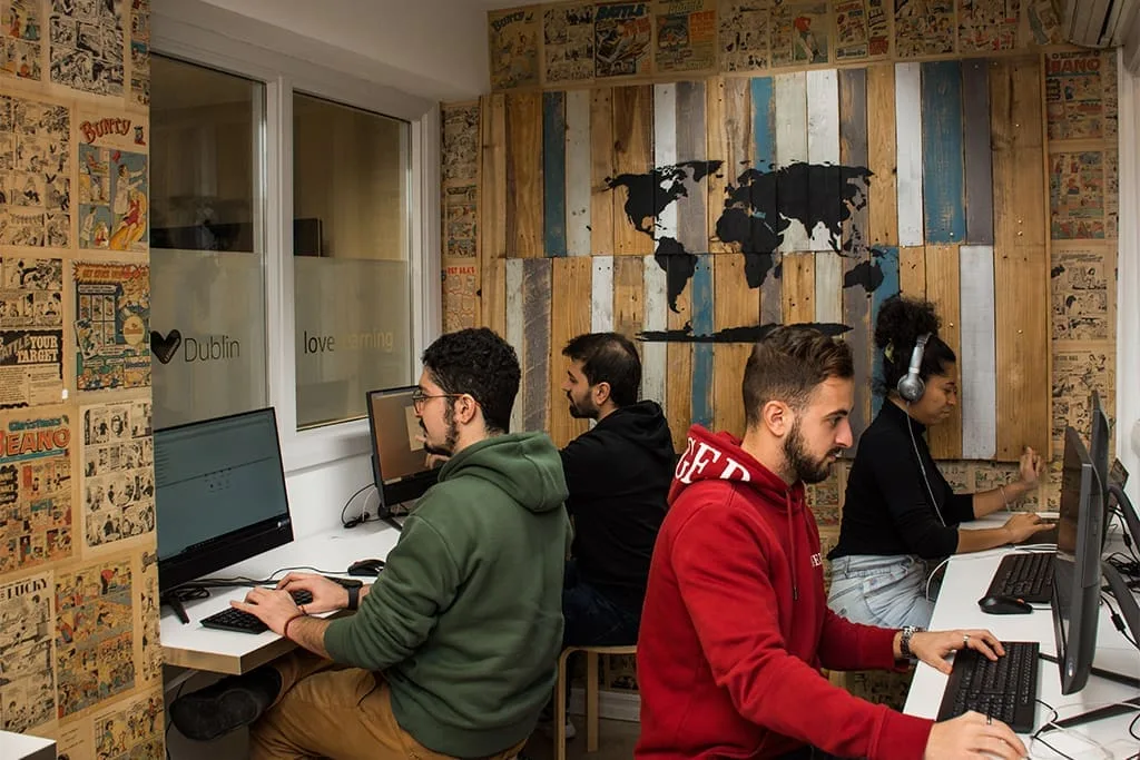 Students using computers in the ISI Dublin study room, surrounded by creative wall decorations.