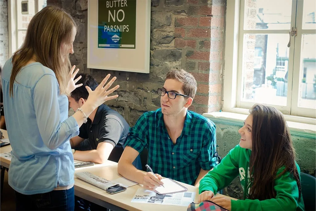 Teacher explaining an activity to students in a bright classroom at ISI Dublin.