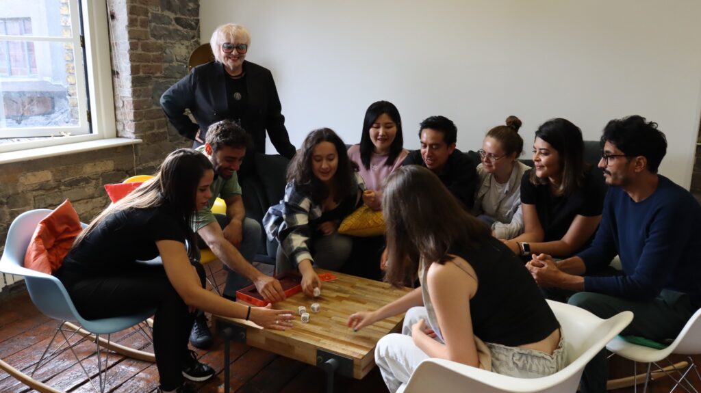 Studenten spielen ein Würfelspiel an einem Tisch im ISI Dublin